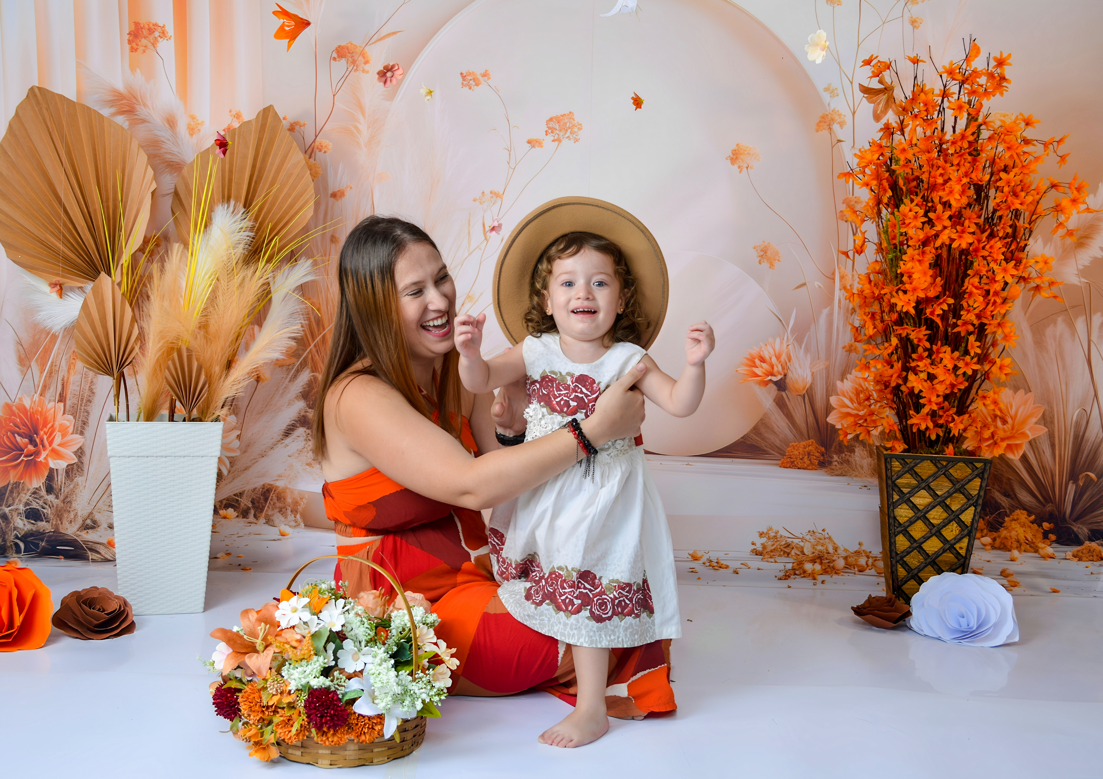 Menina sorrindo e fazendo pose em um ensaio fotográfico, com cenário decorado em tons de outono.