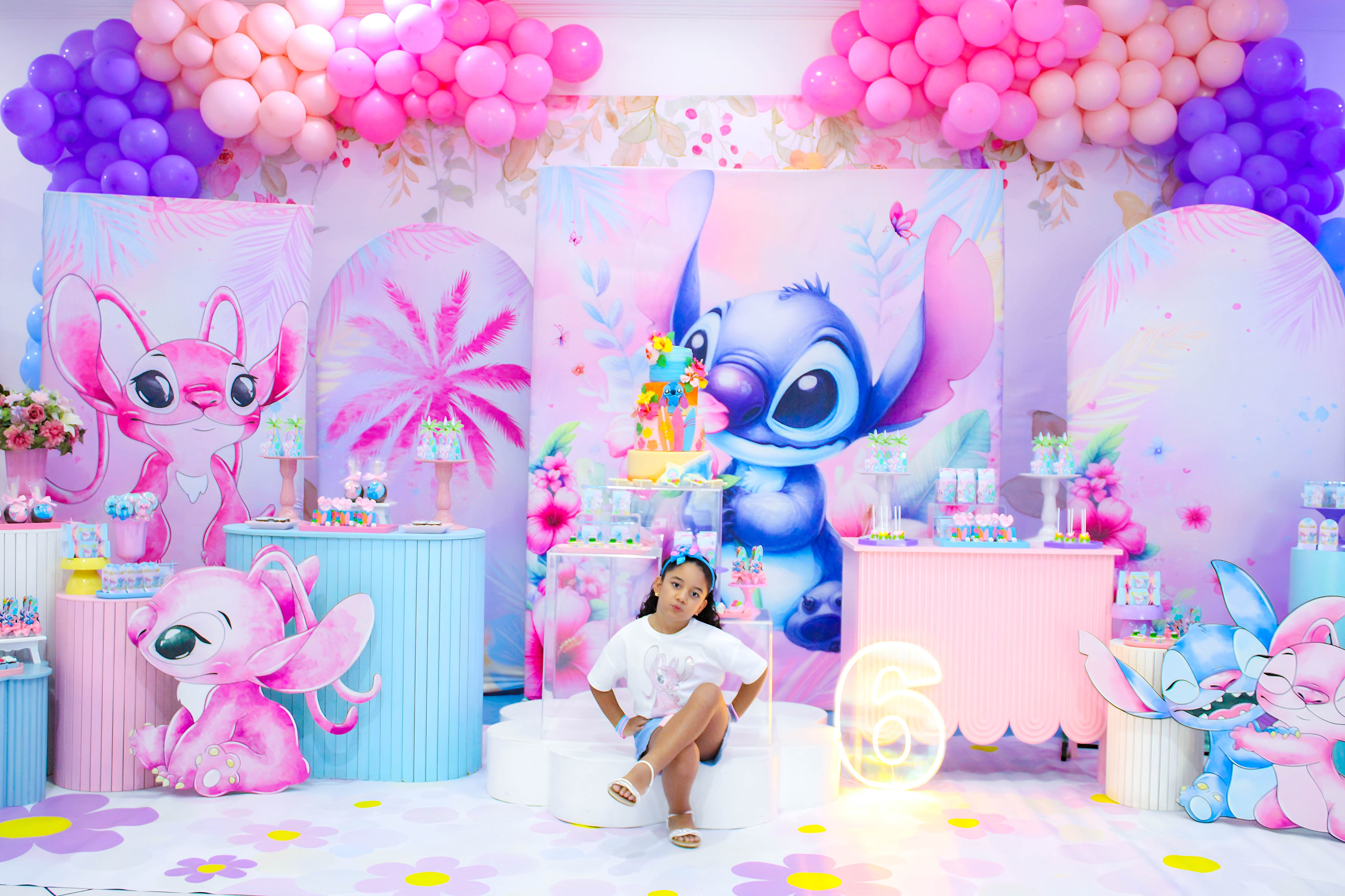Criança sorrindo enquanto brinca em um brinquedo colorido, durante a festa temática do Stitch.